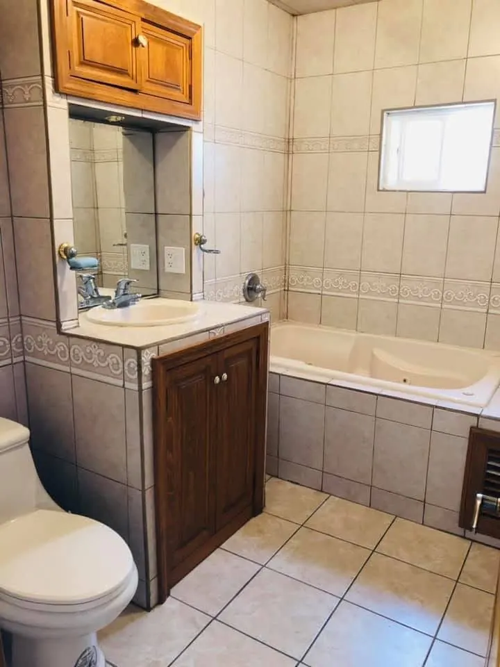 Baño privado con tina, lavabo y azulejo limpio.