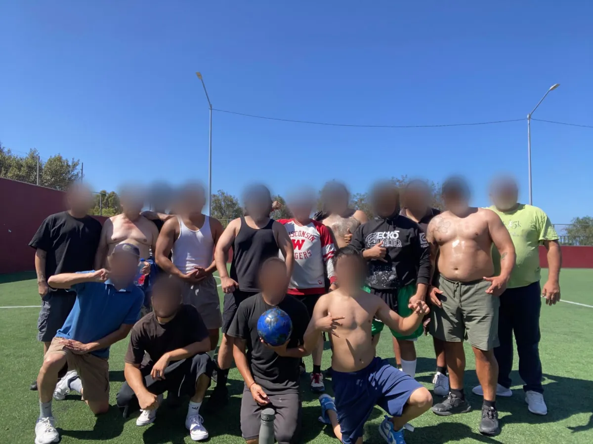 Salida deportiva de Despertares: el grupo de residentes posa con un balón en una cancha de pasto sintético, con los rostros difuminados.